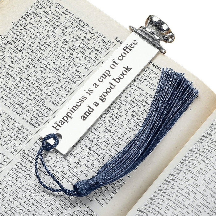 bookmark with quotes by Judi Glover Art. The metal bookmark has the quote happiness is a cup of coffee and a good book. The metal bookmark is shown laying on a book.