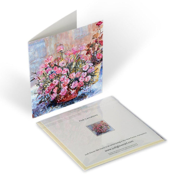 Showing the art greeting card standing up and the back of the carnation card laying flat. Each floral greeting card by Judi Glover Art is blank with envelopes and measures 6 x 6 inches