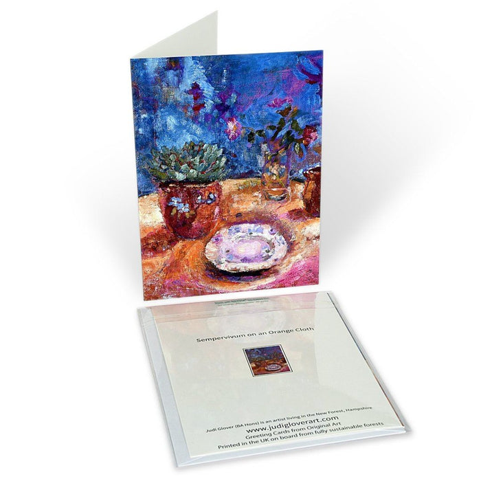 Fine art greeting card. Art card made from original art. A still life painting of sempervivum on a table with roses. This is available as a still life greeting card and still life art card. The original art painting card was made with oil paint on linen. Available at Judi Glover Art. Painted by Judi Glover.