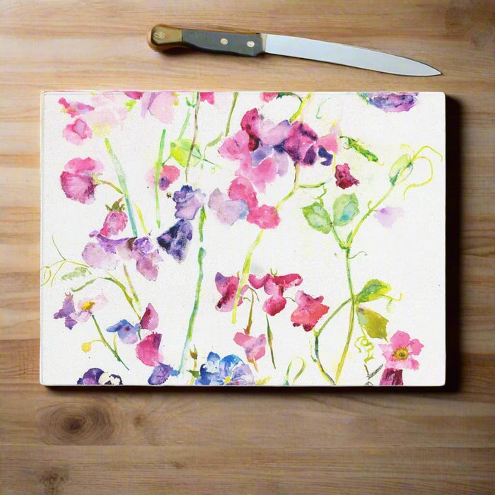 This pretty glass chopping board is hard wearing, versatile and made from a painting of sweet peas. The floral delicate pattern by Judi Glover Art makes a decorative worktop saver or kitchen gift and is made by glass experts from durable, toughened glass