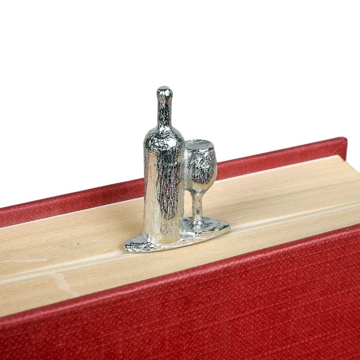 book lover gifts by judi glover art. The metal bookmark with a bottle of wine and a tall glass is shown in a closed book and the book lover gift rests on top