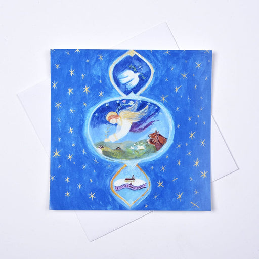A Christmas Church Window Christmas card by Judi Glover, showing an angel, dove and gold stars, displayed with a white envelope