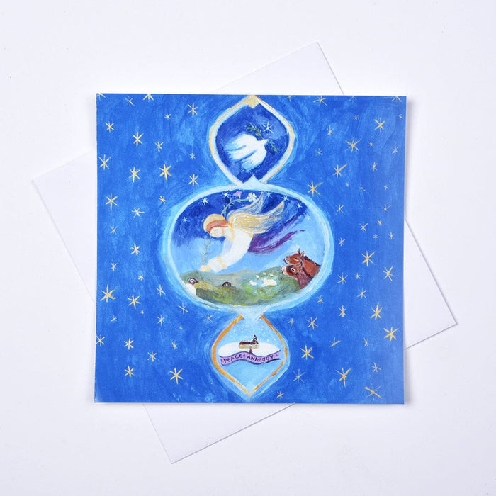 A Christmas Church Window Christmas card by Judi Glover, showing an angel, dove and gold stars, displayed with a white envelope