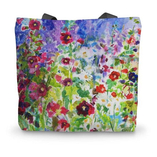 A summer canvas bag with a print of summer flowers hollyhocks and daisies 