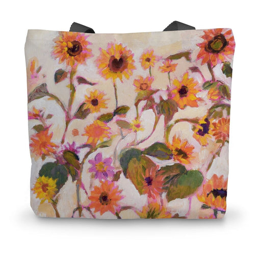 A canvas tote bag featuring a print of sunflowers on a cream background