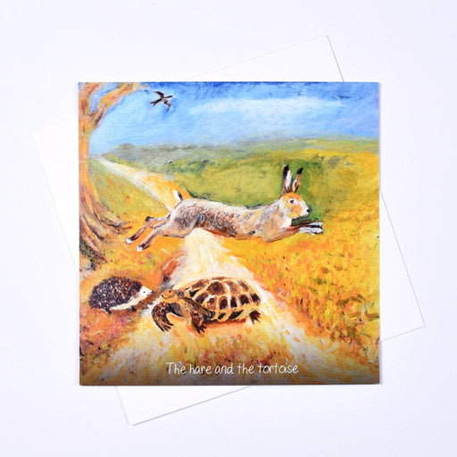 The Hare and the Tortoise greeting card — original art by Judi Glover showing a leaping hare, tortoise and hedgehog on a golden countryside path