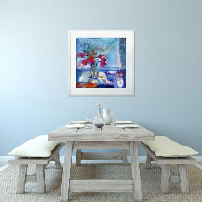 Tulip Wall Art with from a painting of red tulips shown framed on a blue wall above a table and chairs. The tulip prints are available at Judi Glover Art