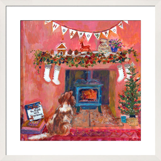 Christmas decor by Judi Glover Art with a Christmas print of a spaniel next to the fireplace and a book of the night before Christmas. The Christmas wall art shows bunting, ivy and a gingerbread house on the fireplace mantle